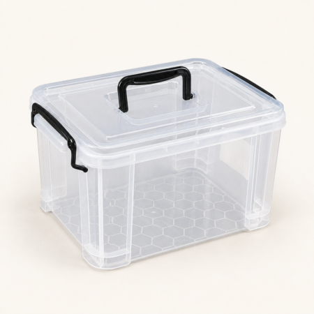 Clear plastic storage box with lid and black carry handles on a warm off-white background